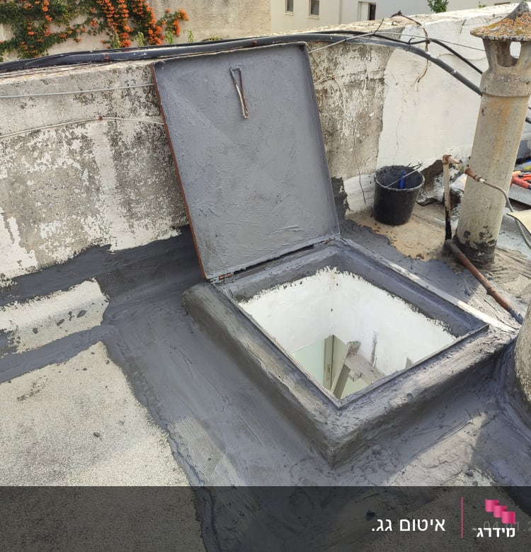 איטום גג עם חומר אפור סביב פתח מרובע